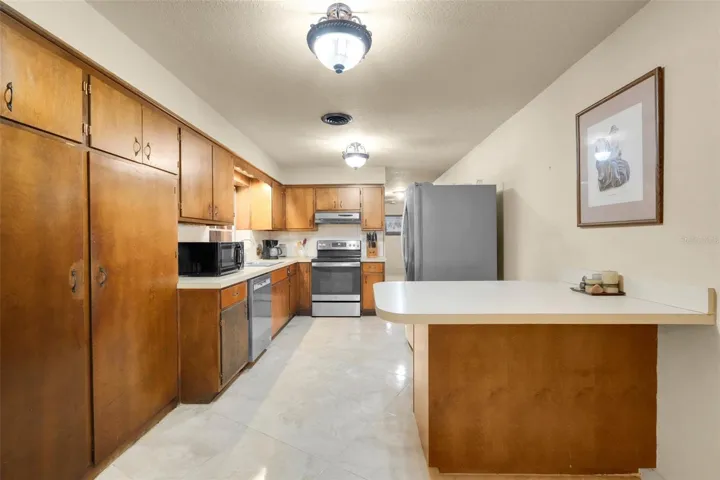 Functional kitchen featuring abundant cabinetry and a built-in breakfast bar for casual dining.