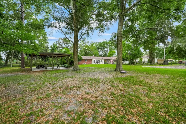 Enjoy wide open outdoor space shaded by mature trees and featuring a covered pavilion- perfect for gatherings, hobbies, or relaxing outdoors.
