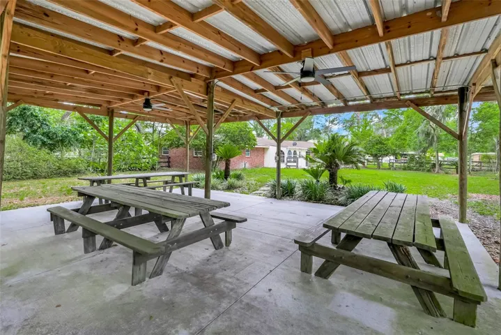 Enjoy outdoor living under the spacious covered pavilion featuring electricity, ceiling fans, lighting, and room for gatherings big or small.