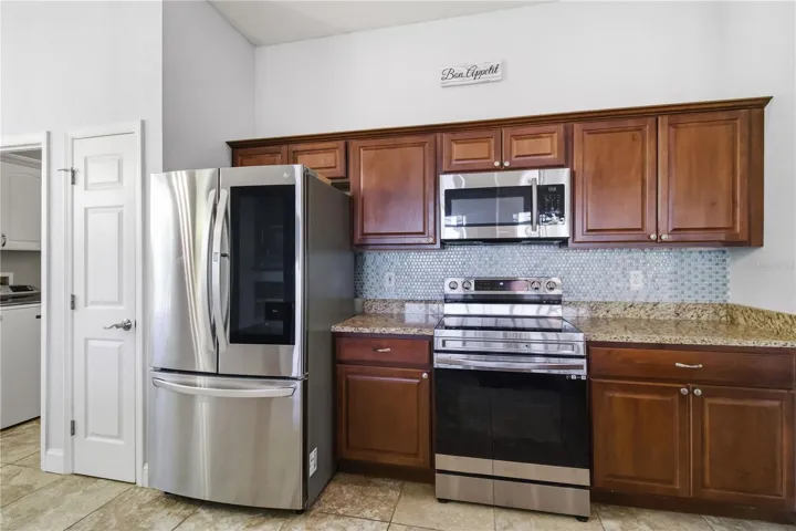 Kitchen with wood cabinetry and tile backsplash