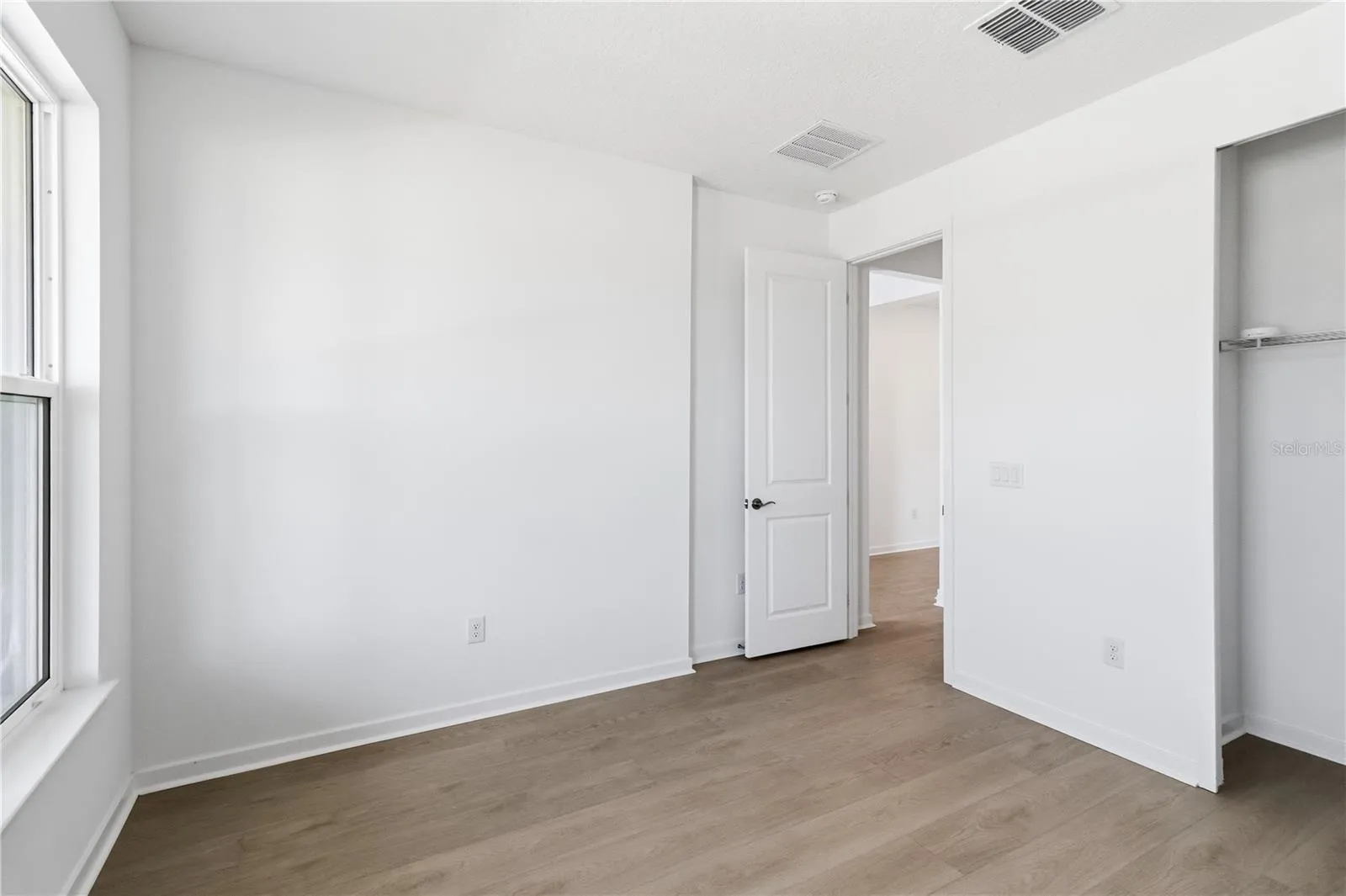 Spacious bedroom with a simple layout, bright walls, and flexible furniture options.