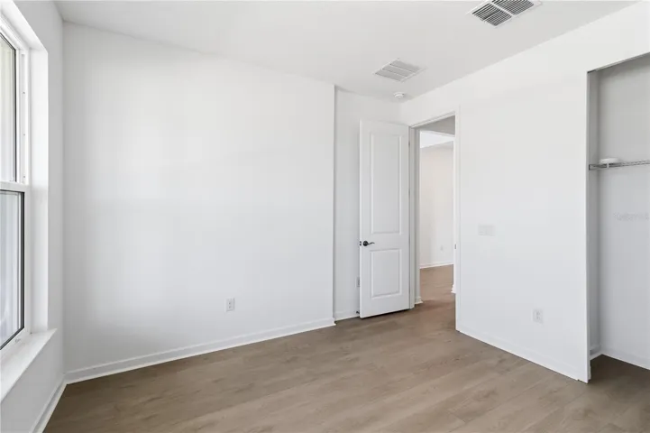 Spacious bedroom with a simple layout, bright walls, and flexible furniture options.