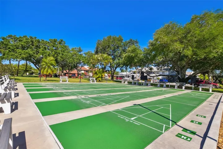 Shuffleboard courts with shaded seating nearby