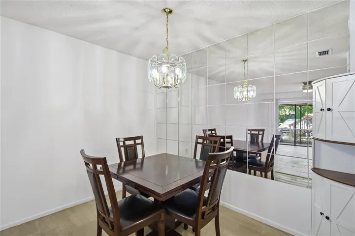 Dining space with mirrored wall and kitchen access