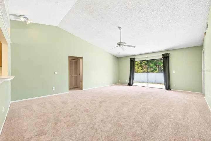 Open living and dining under a vaulted ceiling.