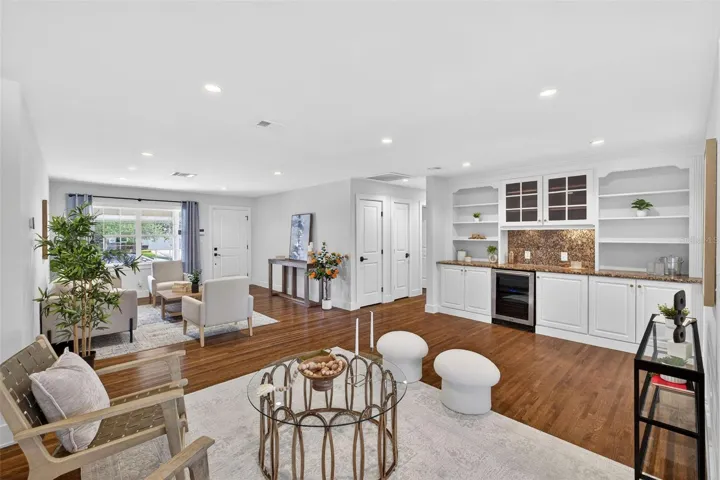 Dry bar area in living room with wine fridge and granite countertops