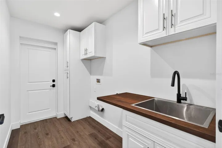 Laundry room with utility sink leading to garage