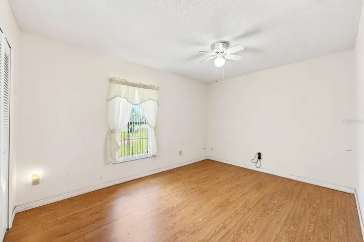 On the opposite side of the home, two additional bedrooms with LAMINATE FLOORING share a SECOND FULL BATH, offering flexibility for guests, family, or a home office. Bedroom 2
