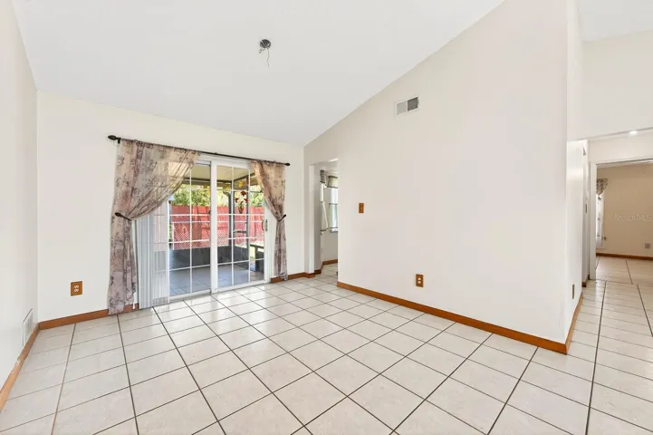 Sliding glass doors from the Dining area open to a SPACIOUS ENCLOSED AND SCREENED PATIO.