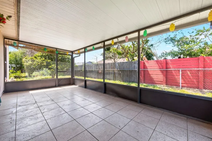 Sliding glass doors from the Dining area open to a SPACIOUS ENCLOSED AND SCREENED PATIO with tile flooring, providing the perfect place to relax while overlooking the GENEROUS FENCED BACKYARD.