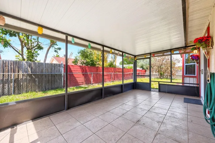 Sliding glass doors from the Dining area open to a SPACIOUS ENCLOSED AND SCREENED PATIO with tile flooring, providing the perfect place to relax while overlooking the GENEROUS FENCED BACKYARD.