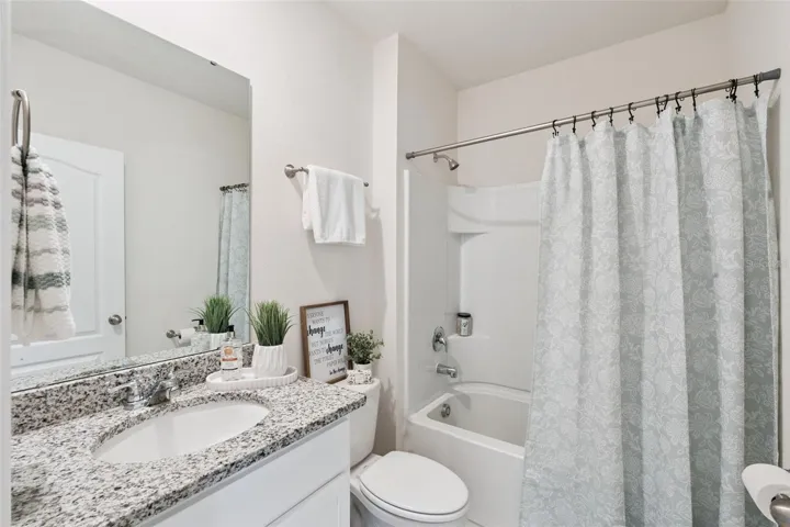 The downstairs full bath can be found off the family, garage and guest bedroom.