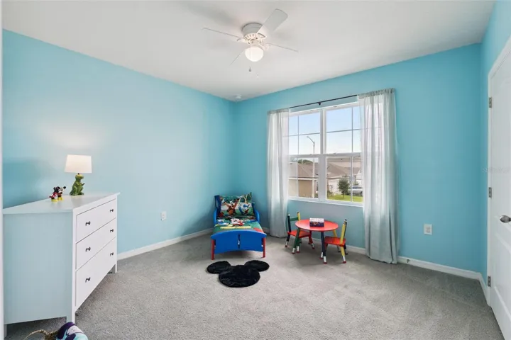 Bedroom 5 with ceiling fan overlooks the front of the home