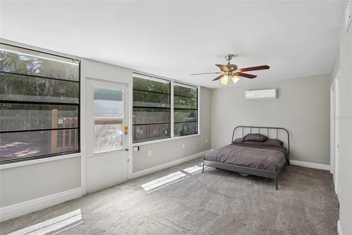 Fourth Bedroom with Poolside Windows - This bright fourth bedroom features a long wall of windows that brings in abundant natural light and creates an open, airy feel. Its location adjacent to the poolside bonus room adds convenience and versatility.