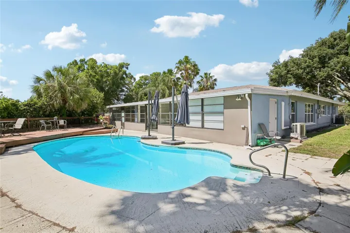 Pool & Rear Exterior – The rear exterior showcases the pool, patio, and long wall of windows along the home, bringing natural light into the interior spaces. The fenced backyard offers a private setting with plenty of room to gather and unwind.