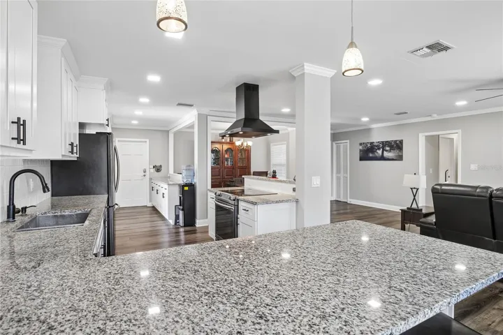 Kitchen & Main Living View – This bright kitchen offers generous granite counter space, a deep sink, pendant lighting, and an open view into the main living area. The layout supports easy everyday use while keeping the kitchen connected to nearby gathering spaces.