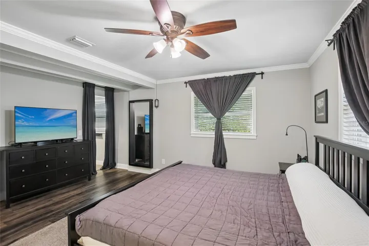 Primary Bedroom Seating Wall – This alternate view highlights the room’s natural light, ceiling fan, crown molding, and flexible wall space for dressers or media furniture. The suite feels open while maintaining a comfortable, private setting.