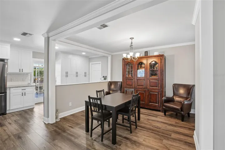 Dining Area – The dining area features an open connection to the kitchen, crown molding, and a central chandelier. This flexible space is well suited for casual meals or hosting guests.