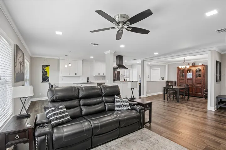 Living Room to Dining Area – A comfortable living area opens to the adjacent dining space and kitchen, creating an easy flow throughout the main living areas. Warm flooring and recessed lighting add a polished, cohesive feel.
