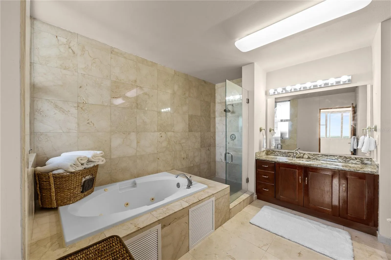 The primary bathroom feels like its own private spa, featuring a spacious layout, a beautiful jacuzzi, and the kind of atmosphere made for slowing down and unwinding.