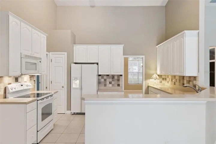 Kitchen view from eating area with dining room in the background