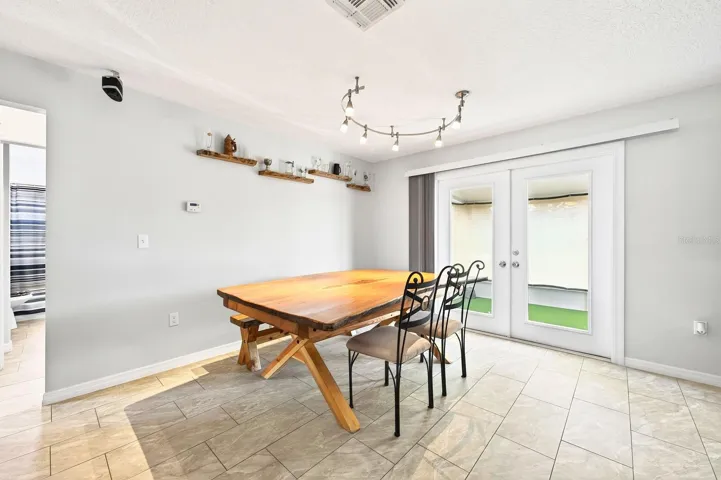 The nearby Dining area features FRENCH DOORS that lead to the covered enclosed patio, blending indoor and outdoor living beautifully.