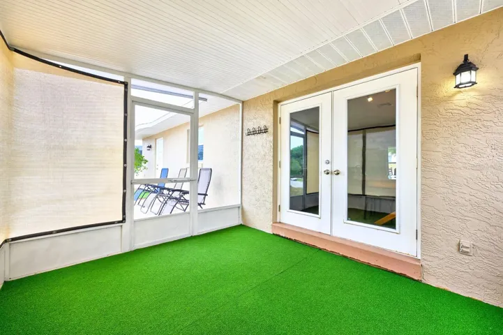 FRENCH DOORS lead to the covered enclosed patio, blending indoor and outdoor living beautifully.