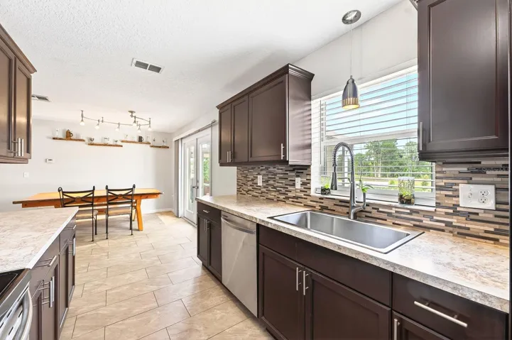 The Kitchen features abundant cabinetry, quartz countertops, stainless steel appliances, a closet pantry, and a NEW SINK, NEW FAUCET, and NEW DISPOSAL added in 2025, combining style and functionality for everyday living.