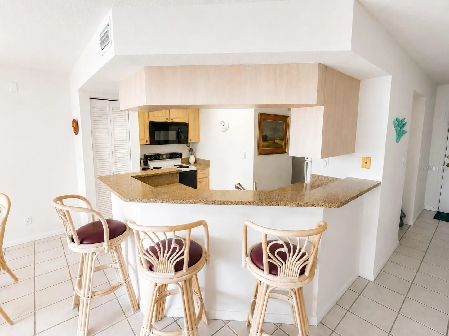 Welcoming kitchen with closet pantry and breakfast bar