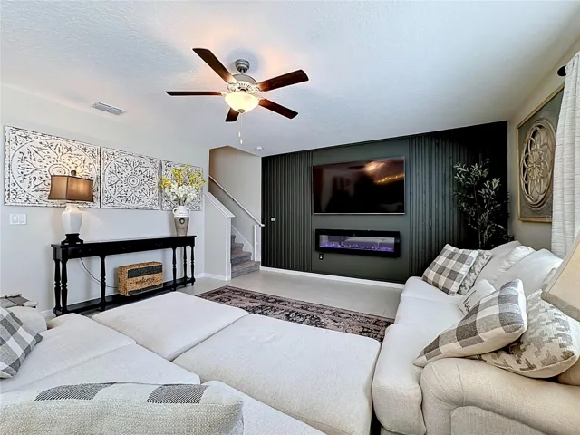 Spacious living room with custom accent wall and electric fireplace