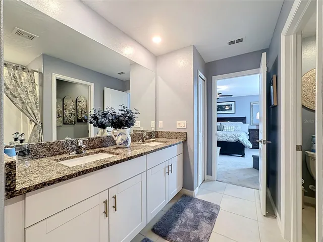 Primary en-suite bathroom with dual sink vanity and step-in shower