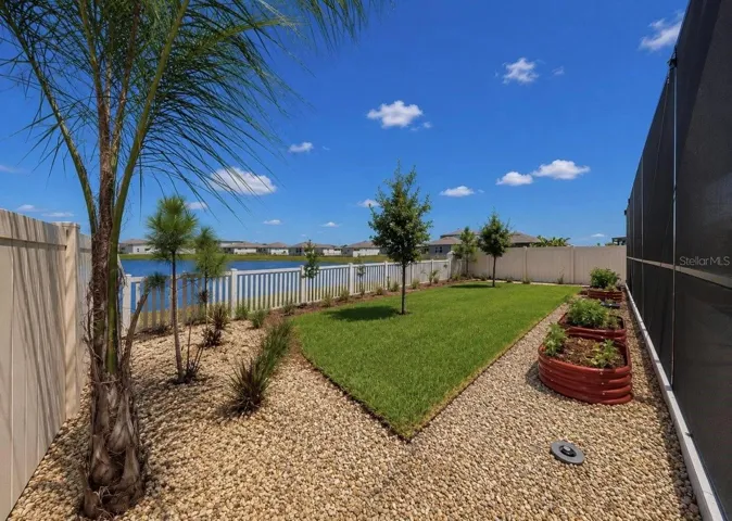 Backyard oasis featuring an enclosed heated saltwater pool and spa, expansive decking, and tranquil pond views