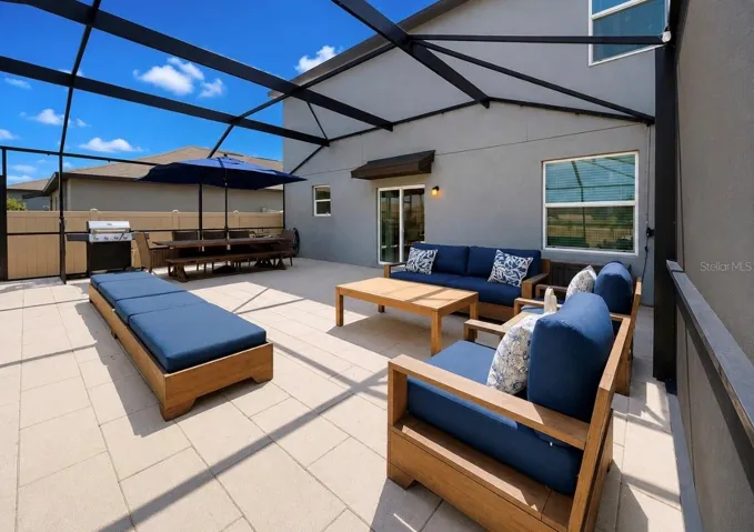 Backyard oasis featuring an enclosed heated saltwater pool and spa, expansive decking, and tranquil pond views