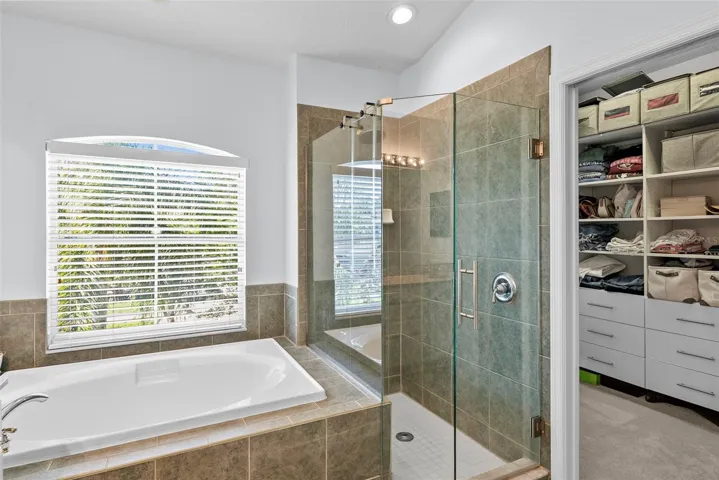 Huge walk in closet with custom organizational shelving in the primary bathroom.