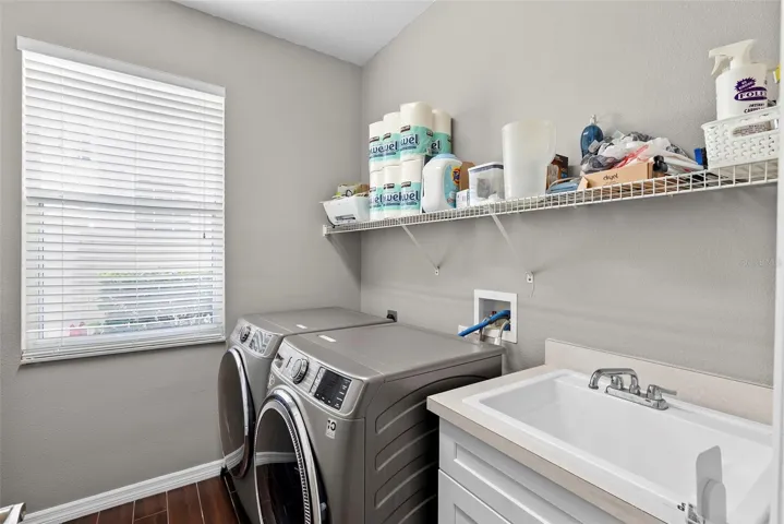 Downstairs laundry room with utility sink and a large organizational closet.