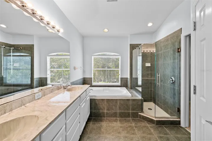 Primary en-suite bathroom with garden tub and frameless glass shower.