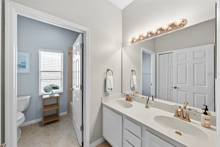 Full hall bath inclusive of dual sinks with privacy door to the commode and tub/shower.
