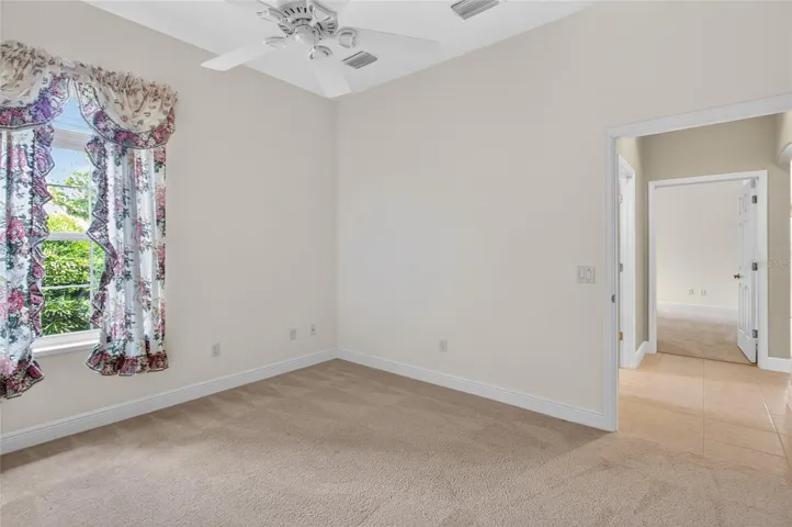 FRONT GUEST ROOM WITH CARPET - TILED HALLWAY LEADING TO THE OTHER GUEST ROOM AND GUEST BATH.