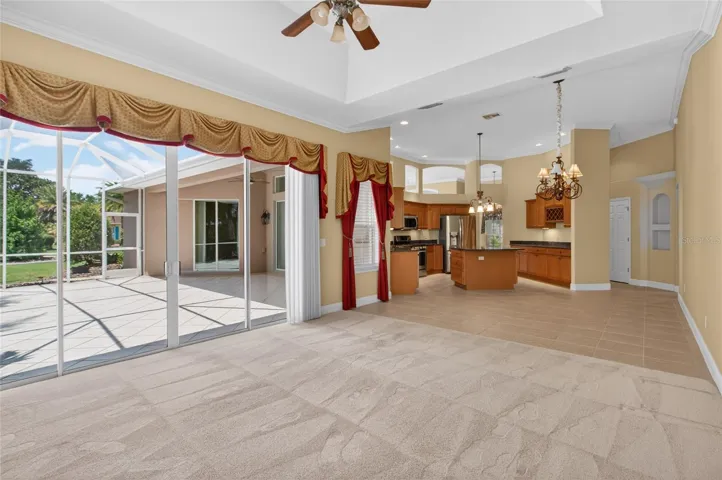 FAMILY ROOM OFFERS A TRAY CEILING AND OPENS WITH SLIDING GLASS DOORS TO THE TILED LANAI.