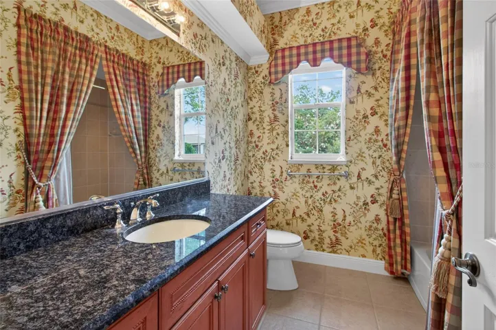 GUEST BATHROOM WITH GRANITE COUNTER TOPS, TUB/SHOWER AND LINEN CLOSET.