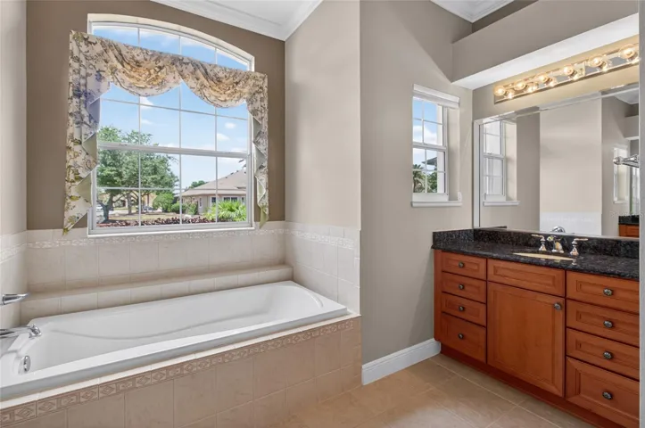 PRIMARY BATH WITH DEEP SOAKING TUB, TWO VANITIES WITH GRANITE COUNTER TOPS, SEPARATE SHOWER, AND TOILET ROOM.