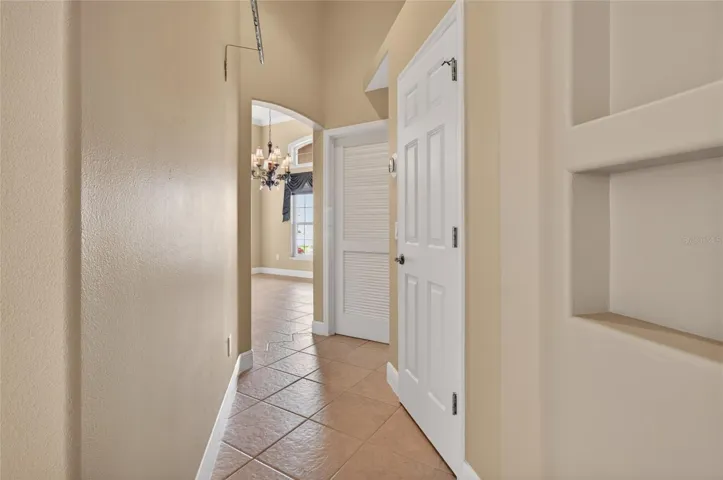 HALLWAY BEHIND THE KITCHEN WITH LOUVERED DOOR LEADING TO THE LAUNDRY ROOM AND THE OTHER DOOR, A NICE LARGE WALK-IN PANTRY.