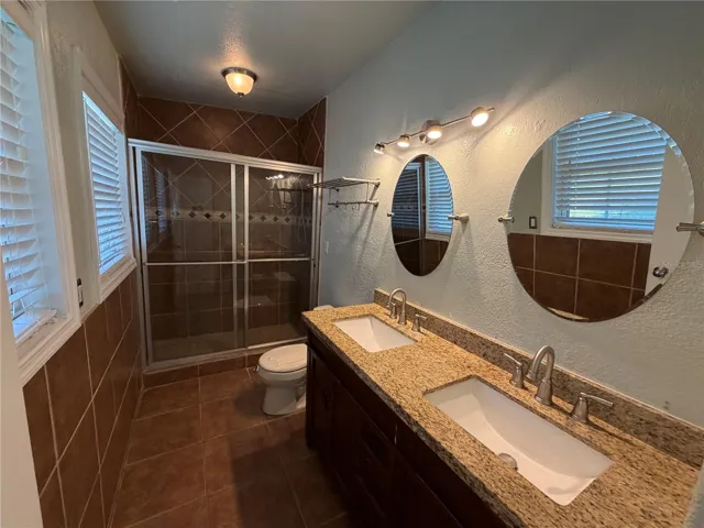 Primary bathroom with dual sink vanity with storage below.