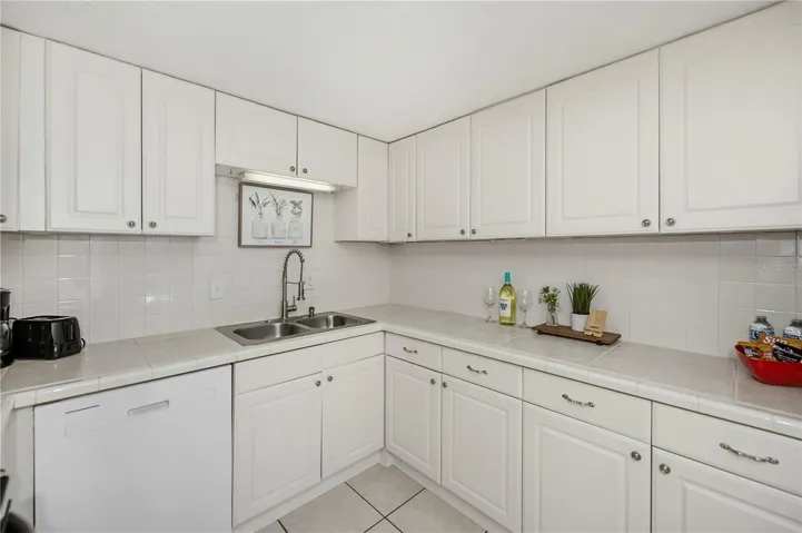 Kitchen with stylish tiled countertops and backsplash