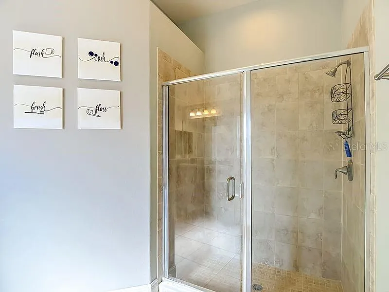Primary bath has a spacious walk-in shower enclosed in glass