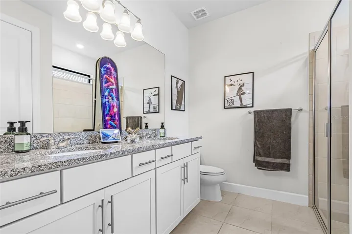 Primary bathroom featuring double sinks, lots of cabinets and  spacious linen closet
