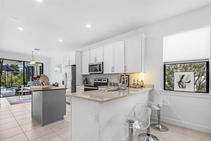 The kitchen and dining area flow seamlessly into the living space and extend to the outdoor living area.