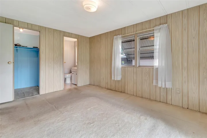 View from inside Primary Bedroom showing walk in closet on left and Primary Bathroom straight ahead