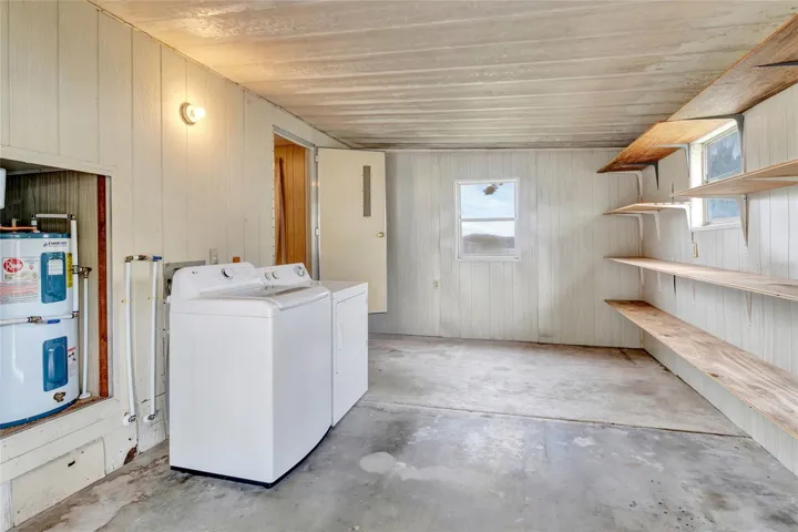 View inside Laundry Room (Cover is off to show the Water Heater and replumb on the left. Door straight ahead is to 2nd Bedroom. Photographer was standing on the seam to the double exterior doors that lock) Double exterior doors are NOT shown in this picture.