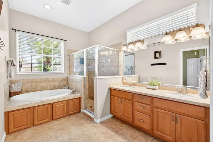 Primary bathroom with natural light, tub and shower